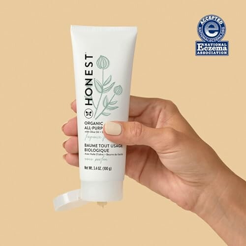 Hand holding Honest Organic All-Purpose Balm with National Eczema Association seal.